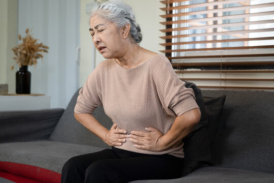 Asian Elderly senior woman stomach ache so pain illness, food poisoning in patient have a bacteria infection,Unhappy elderly painful on stomach vomit and tried need medicine and rest,Elderly Health