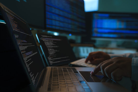 Developers coding a new application project at a multi screen workstation with laptop and digital devices, showing software development workflow, programming process, and technical productivity in dar
