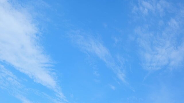 A blue sky timelapse video footage featuring delicate cirrus and thin stratocumulus clouds drifting across the atmosphere, symbolizing calm weather, climate balance and peaceful environmental harmony.