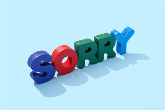 Word SORRY made from colorful letters on blue background