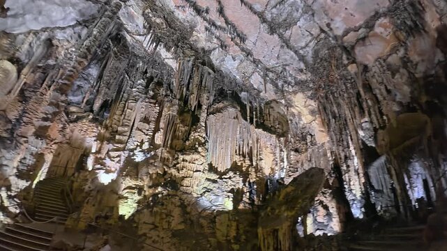 Detailed view of massive stalactites and stalagmites in a limestone cave in Mallorca. Underground geological formations in 4K 30fps for tourism.