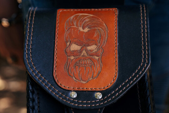 Engraved skull design on leather pouch