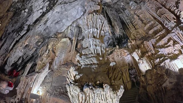 Detailed view of massive stalactites and stalagmites in a limestone cave in Mallorca. Underground geological formations in 4K 30fps for tourism.