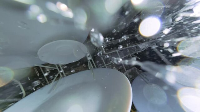 Top Down View from Rotating Arm Inside Dishwasher with Water Spray