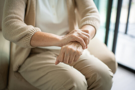 Asian elderly woman touching her wrist pain suffering from arthritis symptoms joint stiffness inflammation and chronic pain in retirement, healthcare insurance coverage for wellbeing