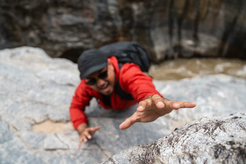 Obraz premium The climber had an accident after falling down the mountain. Hiker climber carefully grips a rock while scaling a steep cliff during a hike in a national park.