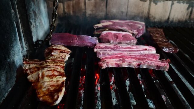 Various beef meat cuts cooking on a hot bbq grill