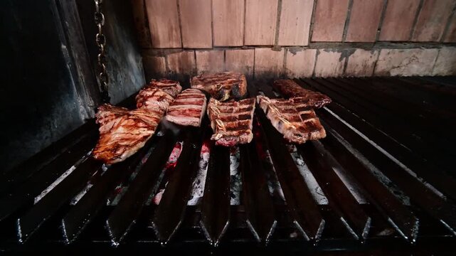 Chef cooking meat and sausages on a traditional charcoal grill