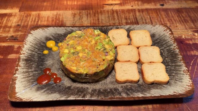 Fresh salmon tartare with avocado served with toasts