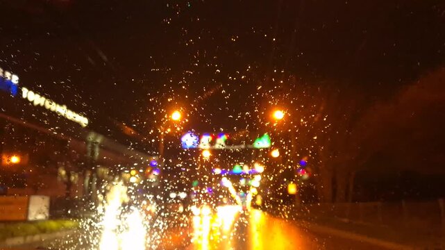 Night driving rain city lights car window view of urban street at night with holiday decorations and blurred festive atmosphere