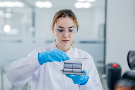 Woman conducts experiment in laboratory with samples in her hands during daylight hours