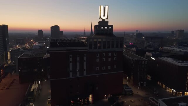 Aerial drone view flying around the u tower in dortmund, germany, during a colorful sunrise