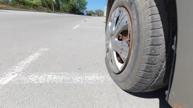 Car driving on a completely flat tire on the asphalt road