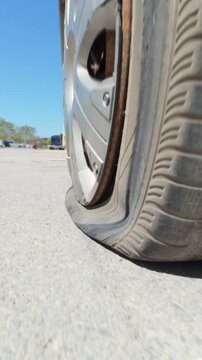 Car driving on a completely flat tire on the asphalt road
