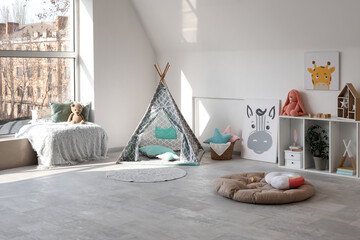 Interior of modern children's room with play tent and toys © Pixel-Shot