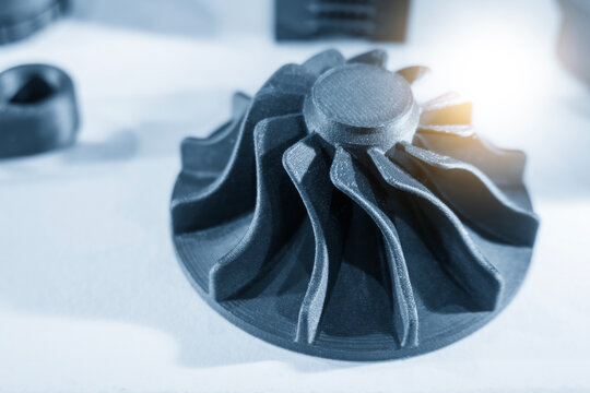 Innovative 3D printed turbocharger part prototype made by metal additive manufacturing in a blue-toned scene.