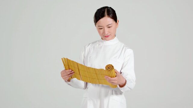 Portrait of traditional chinese medicine physician practitioner female doctor carefully reading information from an ancient book, study materials oriental medicine, continuous learning development