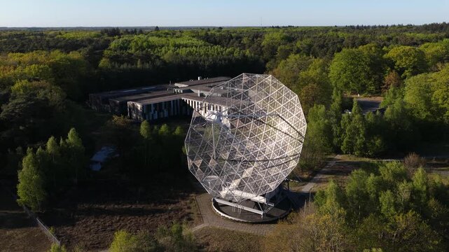 Radio telescope antenna searching for signals in a forest