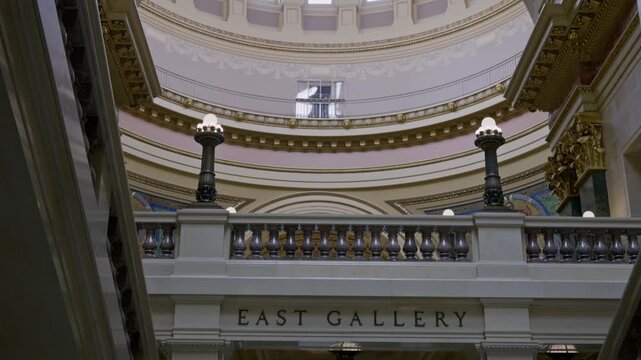 Cinematic gimbal tilt down shot inside Wisconsin State Capitol dome revealing rotunda with detailed interior architecture and smooth motion.