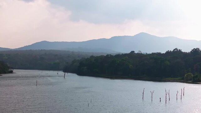 Water with trees, mountains, haze and sky at Chiklihole Reservoir, Attur Forest, Karnataka, india. day time, push in shot, drone shot, 4k.