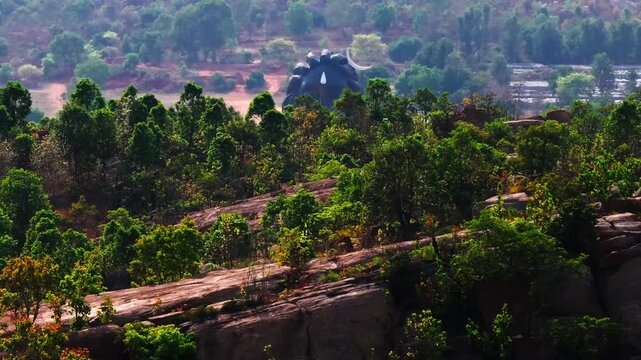 Reveal shot of Adiyogi Shiva statue with Velliangiri Mountains and trees at Isha Foundation Chikkaballapura, Avalagurki, Bengaluru, Karnataka, india. day time, push in shot, drone shot, 4k.