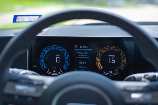Hybrid status cluster. Dash displays speed, RPM, fuel level, auto-shutdown countdown across dualgauge layout. Smooth illumination, crisp digital contours create refined, hightech aesthetic