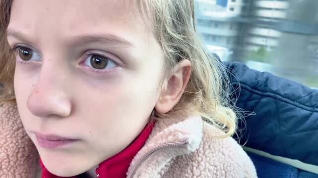  Tired young girl sitting in a subway car during a commute