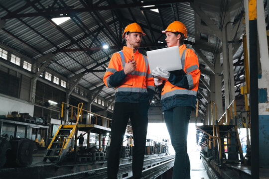 Construction engineer safety helmet uniform industry factory teamwork laptop inspection construction engineer discuss inspection with laptop inside factory warehouse, safety teamwork focus