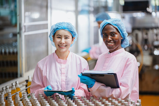 Food and drinks Industry people workers. Line product inspector in beverage factory for food safety.