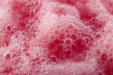 Fototapeta premium Macro of pink bubbly foam with glossy texture, fresh and vibrant style; abstract liquid concept for skincare, cleaning ads, beverages, backgrounds, and cosmetic branding