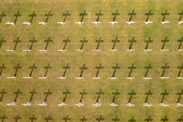 Naklejka premium Aerial View of Rows of White Crosses at a Military Cemetery