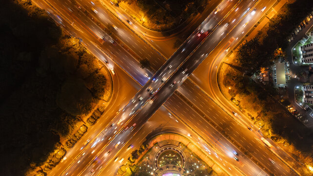 Top View Aerial of Busy Highway Interchange at Night with Light Trails