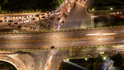 Naklejka premium Aerial Top View of Busy City Traffic Jam and Light Trails on Flyover at Night