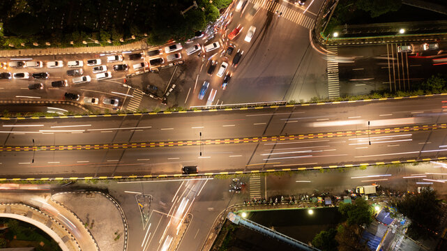 Aerial Top View of Busy City Traffic Jam and Light Trails on Flyover at Night