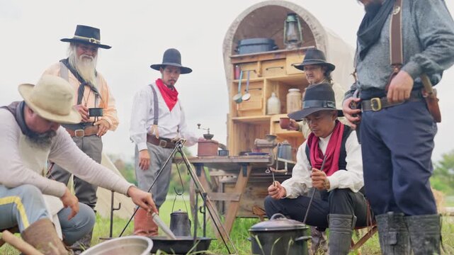 One cowboy prepare meat of roast in a pan for the member of caravan during travel to the target place.