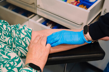 Obraz premium Nurse Applying Cotton After Blood Draw on Female Patient's Arm. Healthcare, patient care, and medical aftercare concepts.
