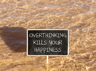 Naklejka premium Overthinking kills your happiness symbol. Concept words Overthinking kills your happiness on beautiful blackboard. Beautiful sea background. Business overthinking kills happiness concept. Copy space
