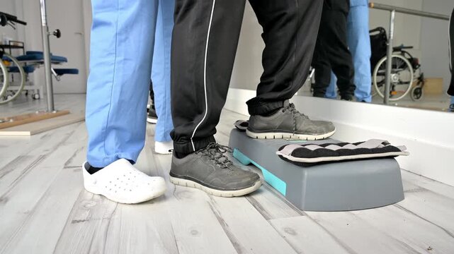 Close-up of patient performing mobility and balance rehabilitation exercises in physiotherapy clinic under professional supervision during recovery session. High quality 4k footage