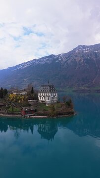 Vertical Droneshot of Iseltwald canton Bern in Switzerland during Spring. Iseltwald is surrounded by the lake Brienzersee and mountains.