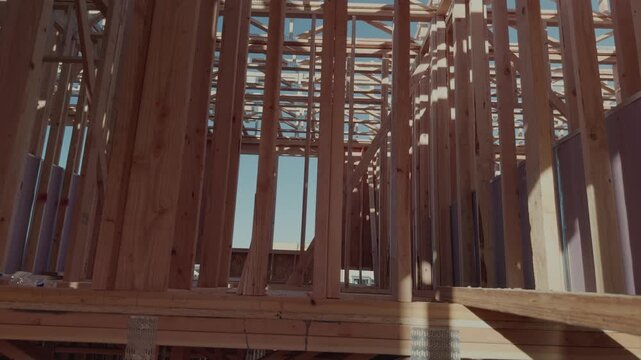 Slow rotating pan from floor to ceiling through wooden framing structure.