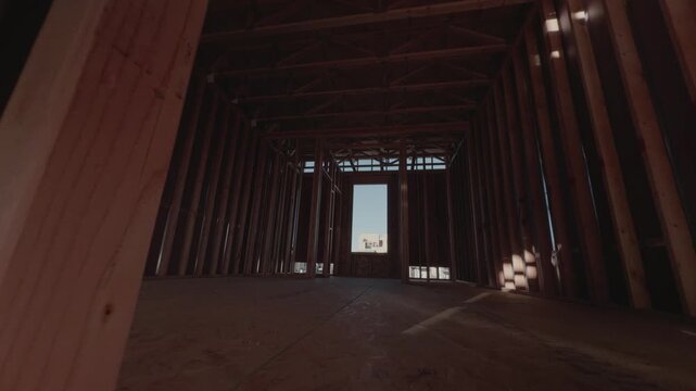 Smooth forward glide moving deeper into unfinished wooden structure.