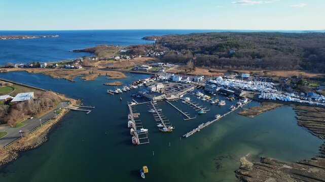 Aerial orbit shot of Cape Ann Marina with moored boats and blue ocean, Gloucester, Massachusetts, USA