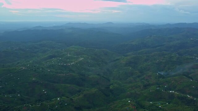 Hillside smallholder farmland with mixed crops and scattered villages in Western Region Uganda within Albertine Rift highlands showing intercropping and ridge valley agriculture drone forward shot