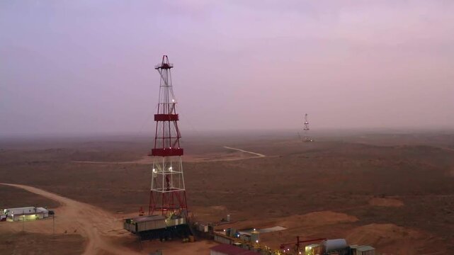 Aerial view of oil drilling rig in desert gas field landscape.
