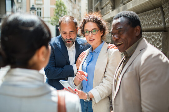 Business colleagues using smartphone on city street