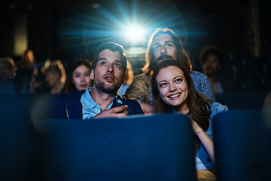 Friends watching a movie in a cinema theater