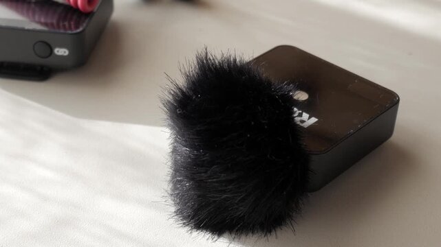 Lavalier mic with furry cover on white table, intimate indoor setting