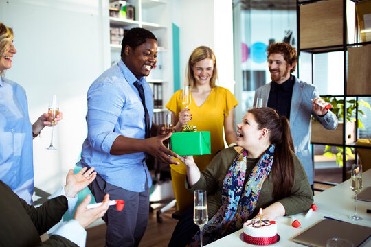 Coworkers celebrating birthday with gift in office