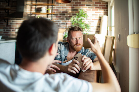 Two men having serious conversation at home