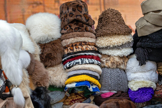 Pile of warm colorful fashion winter hats sold outside on market